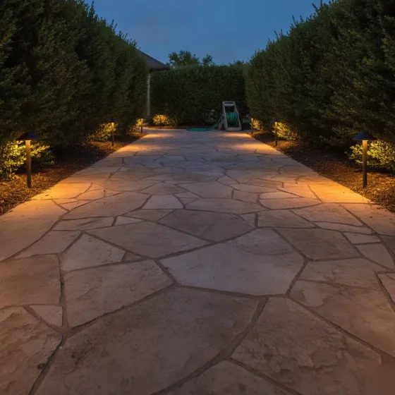 Finished pathway lighting installation glowing along stone walkway in Denton yard